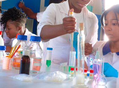 Test tesisi. Genç Afrikalı bilim adamları veya tıp öğrencileri, pozitif enerjik kadınlar, kan, nükleik asit ve Covid-19 hastalarından alınan örnekler üzerinde birlikte çalışırlar..