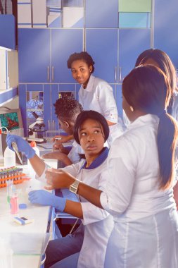 İnsanları koronavirüsten koruyan aşının geliştirilmesi dünya çapında covid-19 virüsü salgınına neden oldu. Laboratuvarda çalışan enerjik Afrikalı kadın bilim adamları veya öğrenciler