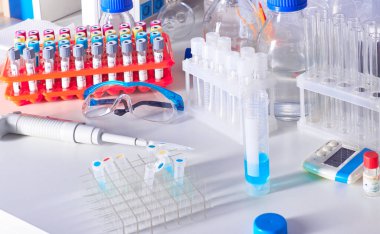 Hasta kan örnekleri, reaktörler, kimyasallar, koruyucu gözlükler, cam şişelerde tampon çözeltileri olan bilimsel bir geçmiş. Çeşitli cam ve plastik tüplerde sıvı bilimsel veya tıbbi örnekler.
