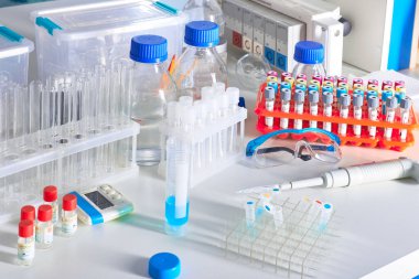 Hasta kan örnekleri, reaktörler, kimyasallar, koruyucu gözlükler, cam şişelerde tampon çözeltileri olan bilimsel bir geçmiş. Çeşitli cam ve plastik tüplerde sıvı bilimsel veya tıbbi örnekler.