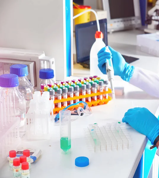 Young African female tech or scientist in protective glasses works with medical blood samples in test lab. Testing patients with viral pneumonia Covid-19 caused by SARS-Cov-2 virus..