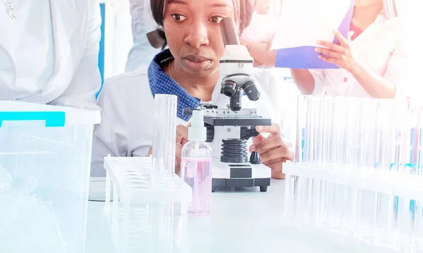 若いアフリカの女性科学者 医療や技術は 検査室や大学の生物学の実用的なコースで顕微鏡を通して患者の生検サンプルを検査します 組織病理学 癌の診断 — ストック写真
