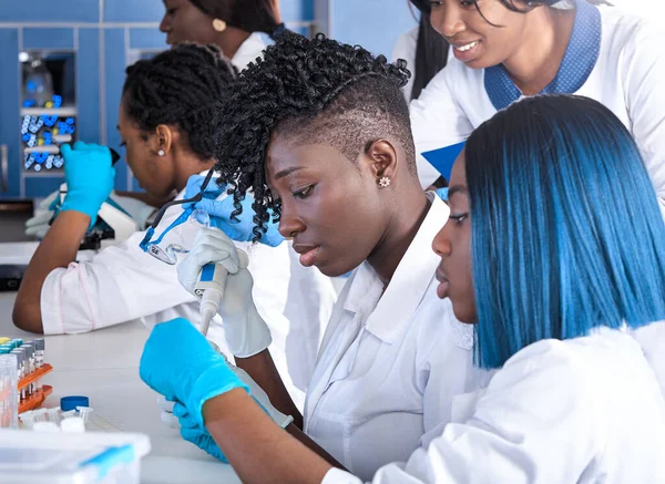 Female African tech women do pcr testing on patients samples in test lab.Female specialists, professionals make nucleic acid test to identify rna for novel coronavirus SARS-CoV-2. Energetic team work.