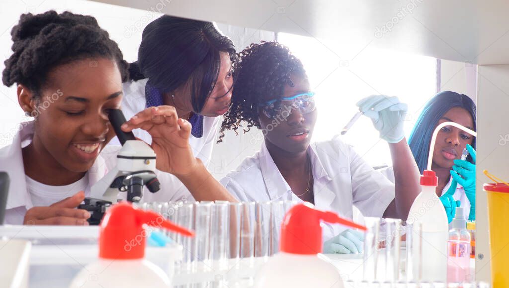 Testing facility. Young African female scientists or medical students, positive energetic women, work together performing blood, nucleic acid and other medical tests on samples from Covid-19 patients.