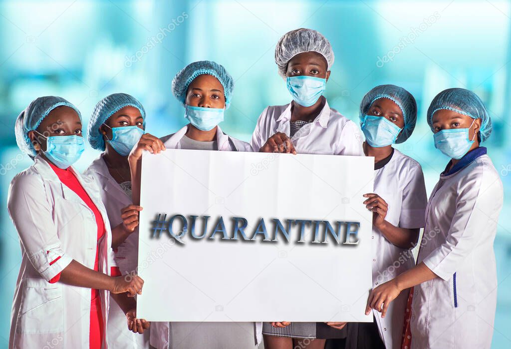 Group of African women nurses activists in face mask with hand sign placard with captions Quarantine. Group of medics with message for public, information campain.