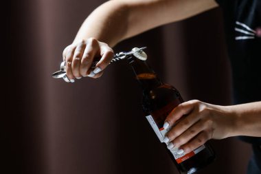 Beyaz tırnaklı kız şişeden bir bardak elma şarabı ve bira döker..