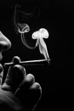 Esrar içen kadın siyah arka planda izole edilmiş. Siyah ve beyaz.