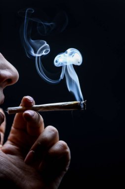 Esrar içen kadın siyah arka planda izole edilmiş..