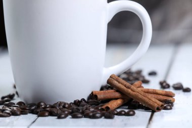  Kahve fincanı, kahve çekirdeği ve ahşap bir masada tarçın. Kahvaltı kahvesi. - Günaydın. Espresso.