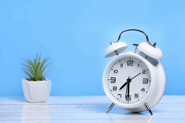 Witte Retro Wekker Houten Tafel Een Blauwe Achtergrond — Stockfoto