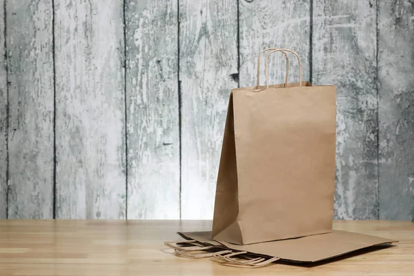 Recycled paper shopping bag on a wooden background. Eco product.