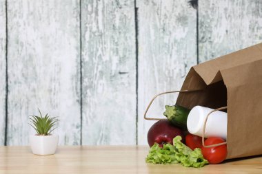 Alışveriş torbası ve bakkaliye. Ahşap arka planda sebzeli geri dönüşümlü kağıt alışveriş torbası. Eko ürün. Sebzeler. Salata.