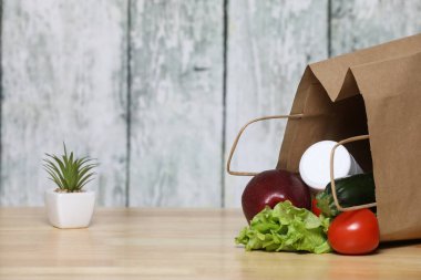 Alışveriş torbası ve bakkaliye. Ahşap arka planda sebzeli geri dönüşümlü kağıt alışveriş torbası. Eko ürün. Sebzeler. Salata.