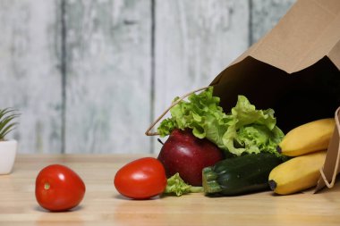 Alışveriş torbası ve bakkaliye. Ahşap arka planda sebzeli geri dönüşümlü kağıt alışveriş torbası. Eko ürün. Sebzeler. Salata.