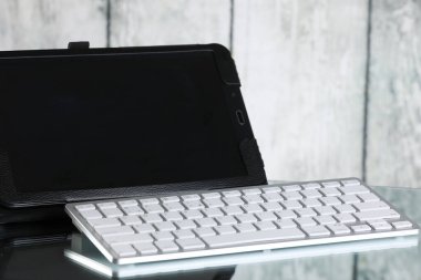 Tablet ve klavye masanın üstünde. Ahşap arka plan. İş yeri. Mali işler. Bağımsız