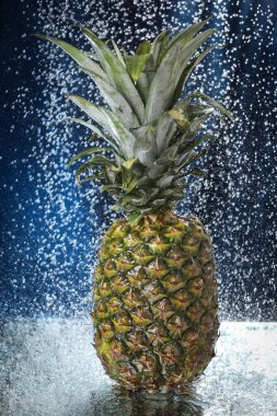 Büyük, taze bir ananas su damlasına yakın duruyor. Su sıçraması. Multivitamin kokteyli. Ananas suyu. Sağlıklı bir yaşam tarzı. Yaz diyeti. Tropik meyve. 