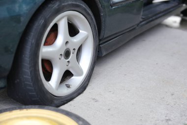 Lastik patlamış. Çivi çaktığı için araba lastiği sızdırıyor. Bir yolda tekerlek hasarı.