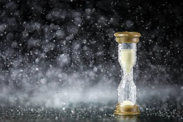 Suyun altındaki kum saati siyah arka planda izole edilmiş. Zaman kısıtlı. Son teslim tarihi. Pazarlama stratejisi. İş çözümü.