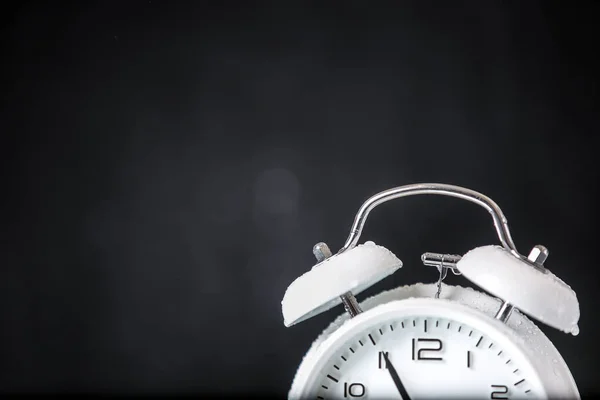 white retro alarm clock in a black background under the water drops.. Morning. Break. Motivation. Business solutions. Success. Deadline.