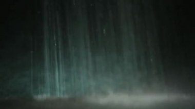 Su damlaları siyah ve yeşil arkaplana düşer.