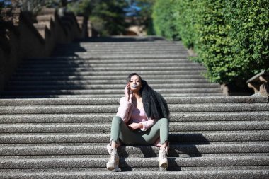 basamaklarında oturan kendine güvenen Bayan