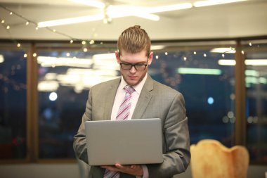 Belgili tanımlık laptop ile ayakta genç adam