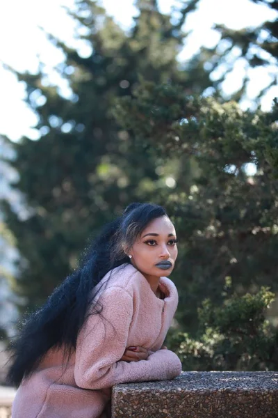 Female wearing blue lipstick and pink coat — Stock Photo, Image