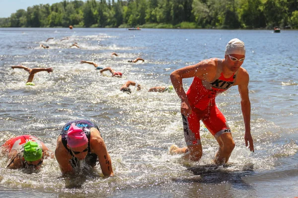 Triatleti dopo aver nuotato in un fiume corre a riva — Foto Stock