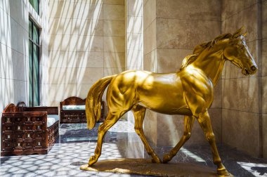 Ajman. Ağustos 2016. Otelin önünde altın at heykeli Ajman Saray.