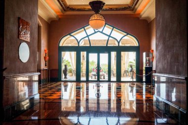 Dubai. 2016 yaz. Parlak turuncu renk hotel Atlantis mermer zemin ile iç belgili tanımlık palmiye.  