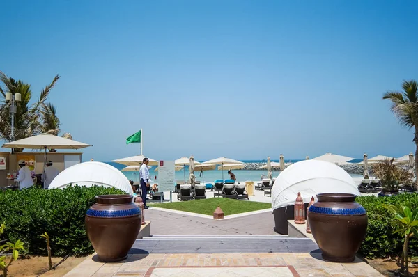 Sonnenschirme und weißer Sandstrand. das emirat ajman. Sommer 2016. — Stockfoto