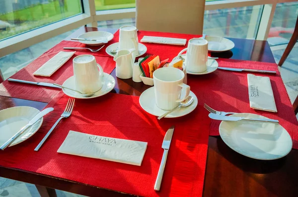 Dubai. Lato 2016. Ułożony stolik w jasnym wnętrzu restauracji Ghaya Grand Hotel. — Zdjęcie stockowe