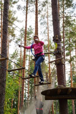 Mutlu genç kadın bir ip parkta aktivite zevk. Ekstrem sporlar. Rusya. Sankt-Peterburg. Sonbahar 2016