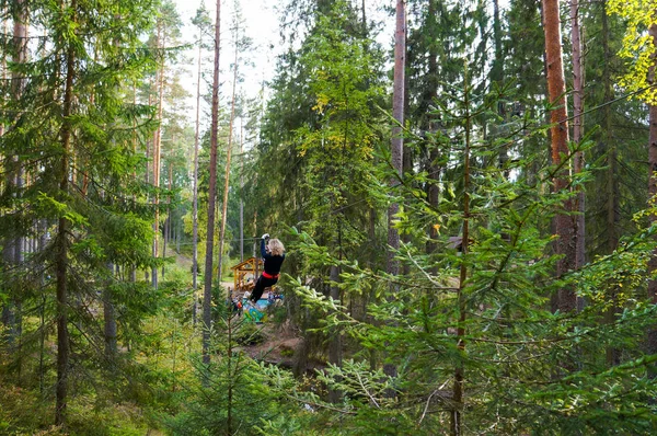 Fröhliche junge Frau, die Aktivitäten in einem Seilpark genießt. Extremsport. — Stockfoto