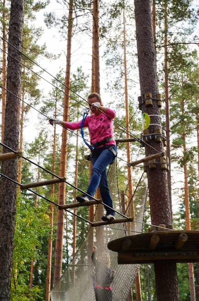 Mutlu genç kadın bir ip parkta aktivite zevk. Ekstrem sporlar. Rusya. Sankt-Peterburg. Sonbahar 2016