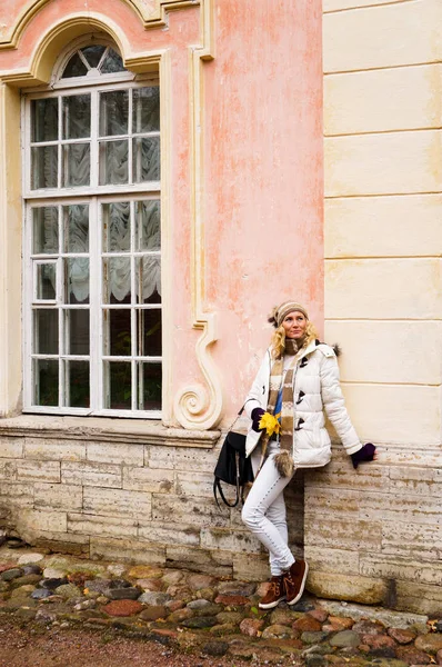 Bayan pembe duvar kemerli pencere ile bir arka plan üzerinde poz Beyaz giysili.