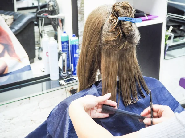 Bild zeigt Friseurin mit Schere und Kamm. Nahaufnahme Friseur schneiden Haare einer Frau in Friseursalon. — Stockfoto