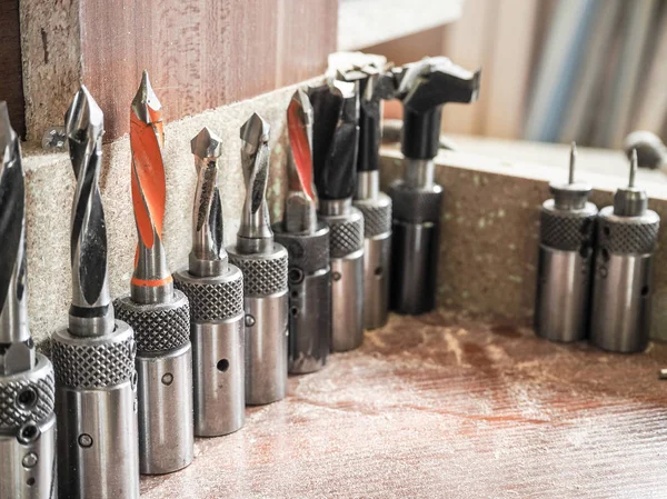Professional drill bits for various purposes in a large assortment standing on the table in the furniture shop.