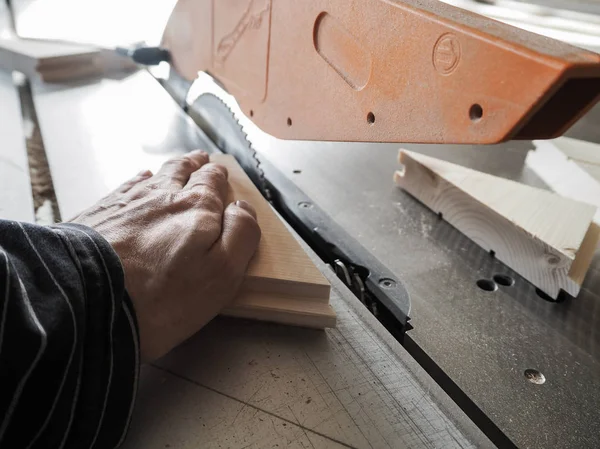 Schneiden der Holzteile an den Maschinen. die Aussicht von oben. Holzteile liegen in der Möbelproduktion auf einer Kreissäge. — Stockfoto