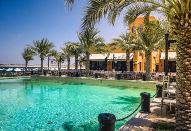 Dubai. Ras al Khaimah göksel vaha. Sahilde şezlong ve şemsiye Dubai, Arap Körfezi'nin kıyısında. Tonlama.