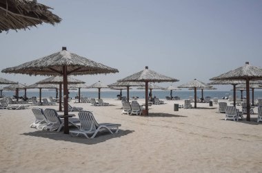 Dubai. Ras al Khaimah göksel vaha. Sahilde şezlong ve şemsiye Dubai, Arap Körfezi'nin kıyısında. Tonlama.