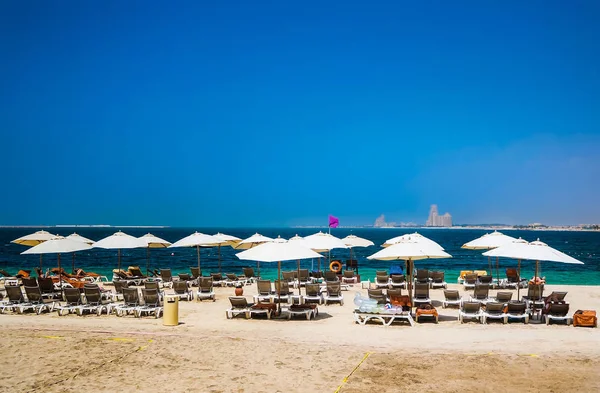 迪拜。在拉斯阿尔卡的天堂绿洲。在海滩上日光浴浴床和遮阳伞在迪拜，阿拉伯湾的海岸上。色调. — 图库照片