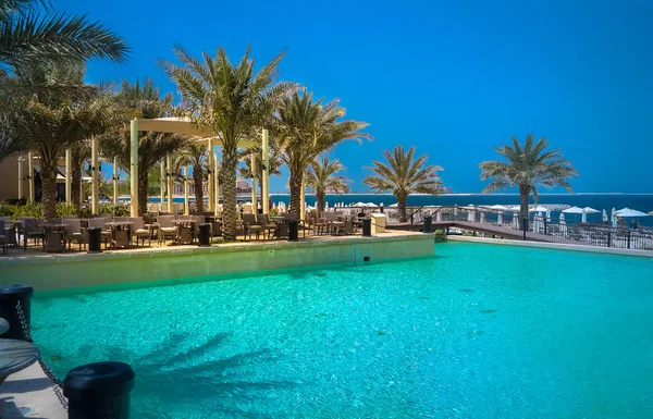 Dubaj. Niebiański oasis w Ras al Khaimah. Plaża z leżakami i parasolami w Dubaju, nad brzegiem Zatoki Arabskiej. Tonowanie. — Zdjęcie stockowe