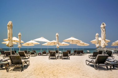 Tropik cenneti. Plaj şezlong ve şemsiye Dubai'de, Basra Körfezi. Emirliği, Ras al Khaimah. Renkli