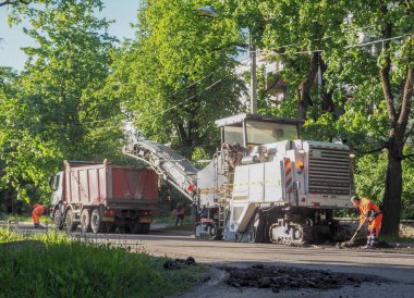 Şehir içinde yol çalışmaları. Özel ekipman üzerinde çalışıyor bir güneşli yaz gününde eski asfalt kesme. Saint-Petersburg. Rusya. Yaz 2017