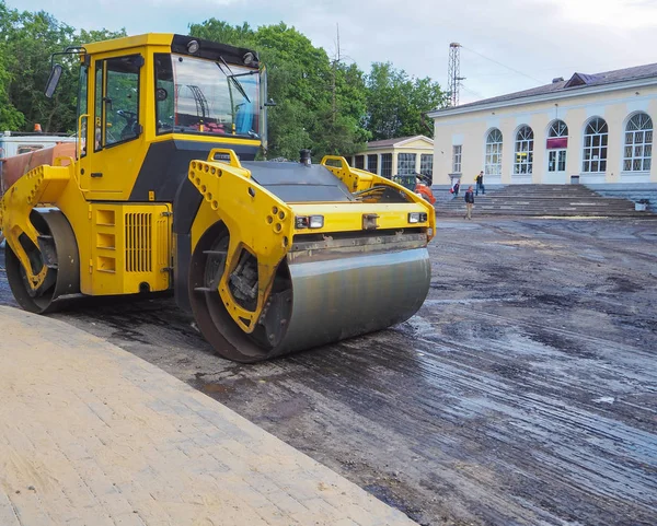 La carretera funciona en la ciudad. Trabajar en equipos especiales cortó el asfalto viejo en un día soleado de verano. — Foto de Stock