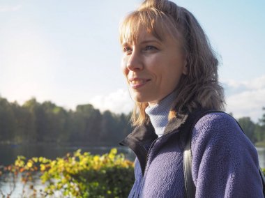 Orta yaşlı bir kadın arıyorum yana, düşmek. Güzel bir arka plan üzerinde bulanık açık kadın portresi.