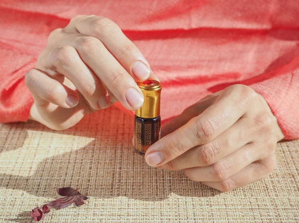Красивые женские руки держат маленький флакон с ароматическим маслом. Арабский Аттар . — стоковое фото