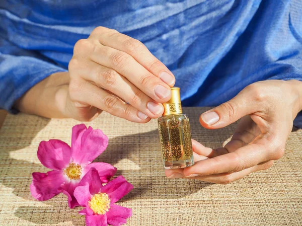 Kokulu yağ küçük bir şişe holding güzel kadının eller. Arap Attar.
