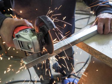 Daire testere ile kesme kıvılcım. Elektrik değirmeni aracıyla fabrikasında, çelik yapı üzerinde çalışan bir erkeğin kıvılcım uçan. 